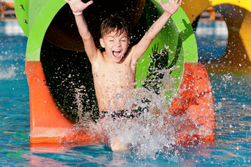 Little Boy Going Down a Slide at a Water Park